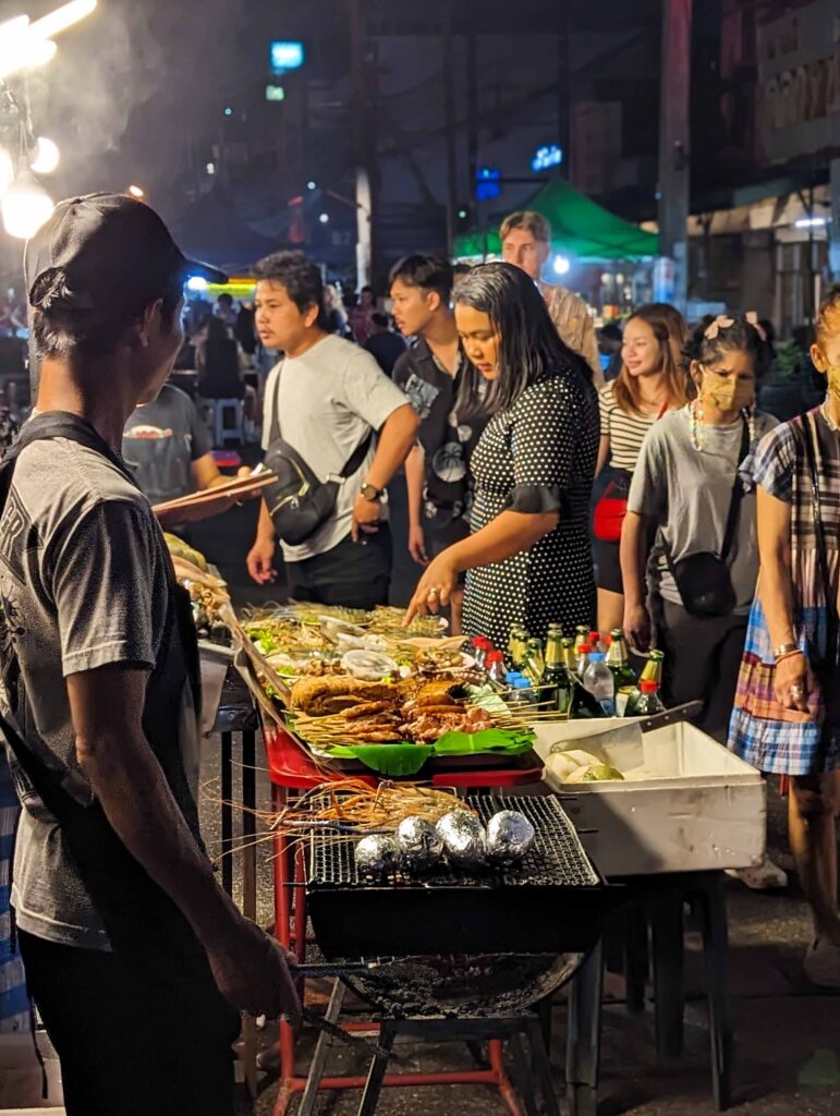People choosing dishes at the night market in Chiang Mai, Thailand